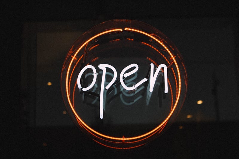 Light up sign with the word open in a circle.